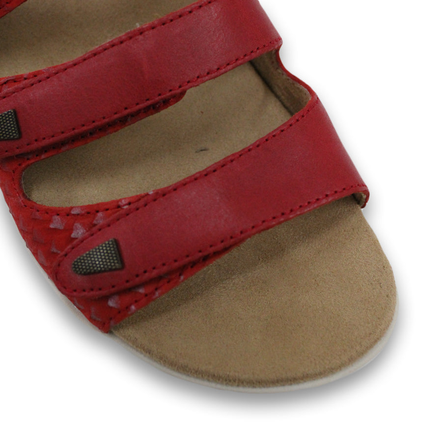 FRONT VIEW OF RED FLAT SANDAL WITH TRANGLE TEXTURED SIDE PANELS, OPEN TOE, OPEN BACK, WHITE SOLE AND THREE STRAPS ACROSS THE FRONT 