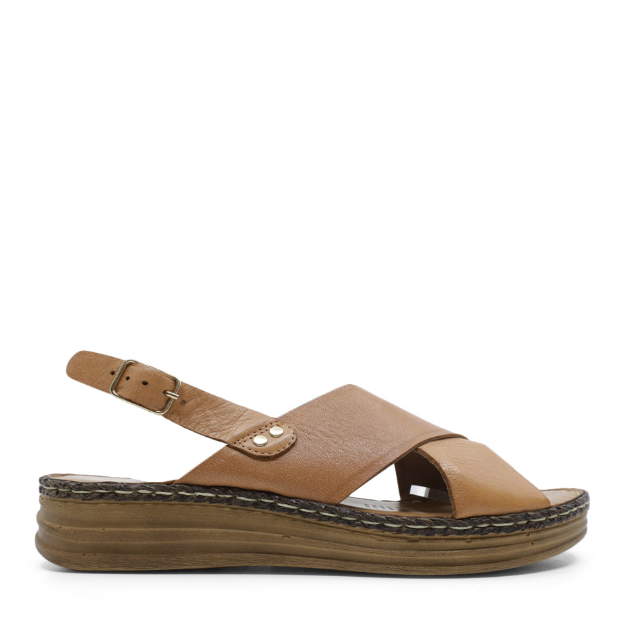 SIDE VIEW OF TAN LEATHER CRISS CROSS FRONT SANDAL WITH ADJUSTABLE BUCKLE AND CUSHIONED SOLE