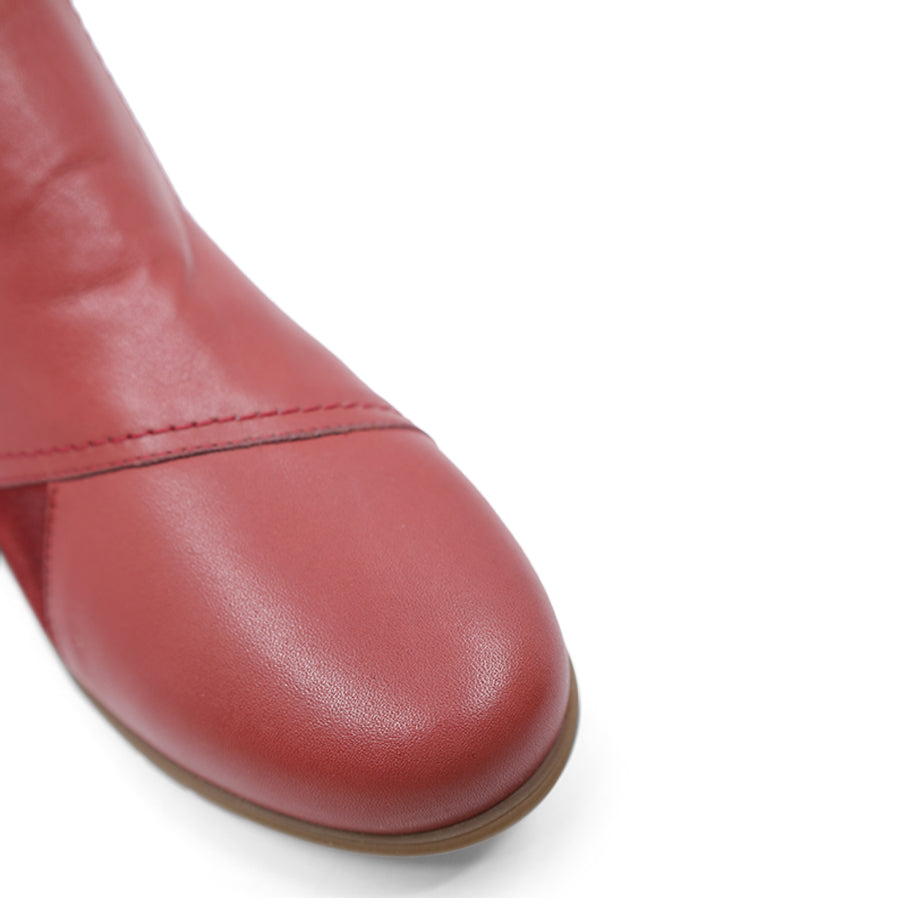 FRONT VIEW OF RED ANKLE BOOT WITH SUEDE ATCHWORK DETAIL AND RUBBER SOLE 