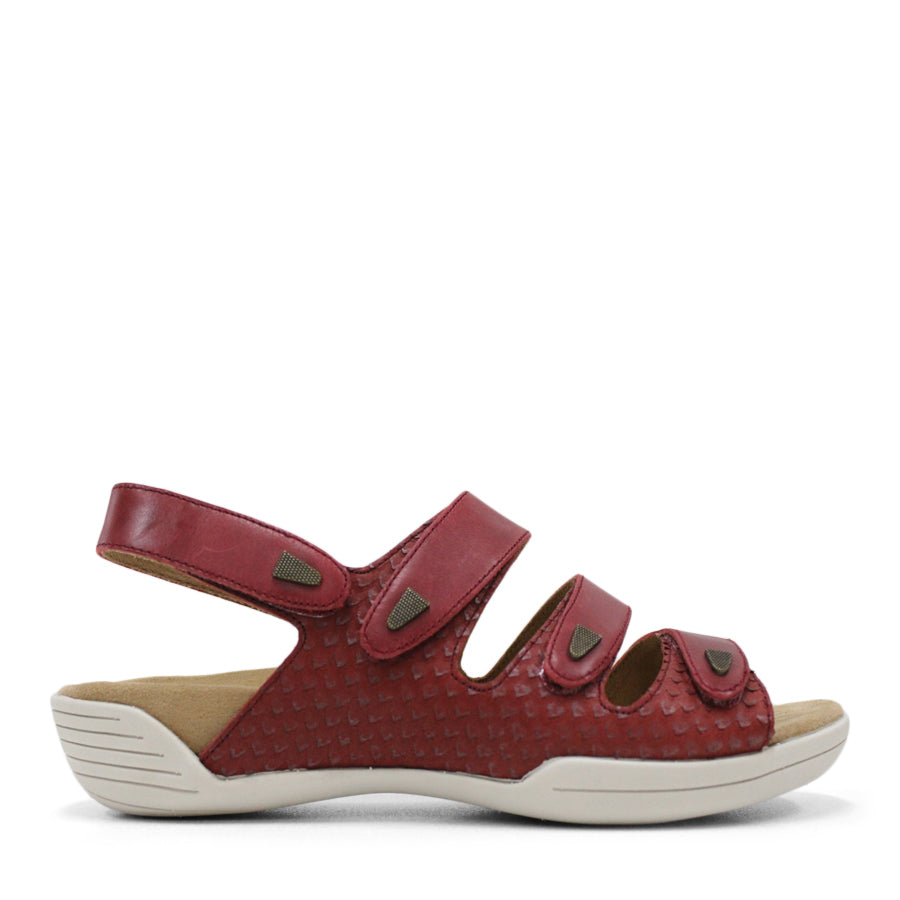 SIDE VIEW OF RED FLAT SANDAL WITH 3 STRAPS OVER THE FOOT AND ONE AROUND THE HEEL. TRIANGLE PATTERN DETAIL. 