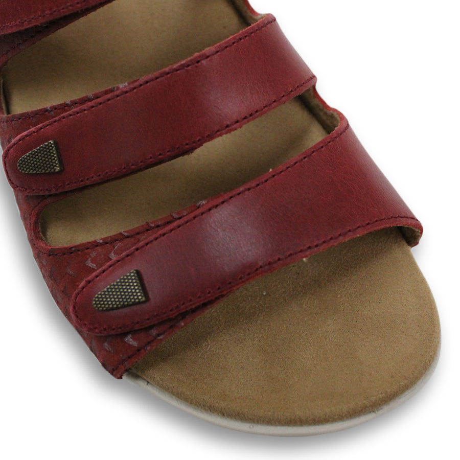 FRONT VIEW OF RED FLAT SANDAL WITH 3 STRAPS OVER THE FOOT AND ONE AROUND THE HEEL. TRIANGLE PATTERN DETAIL. 