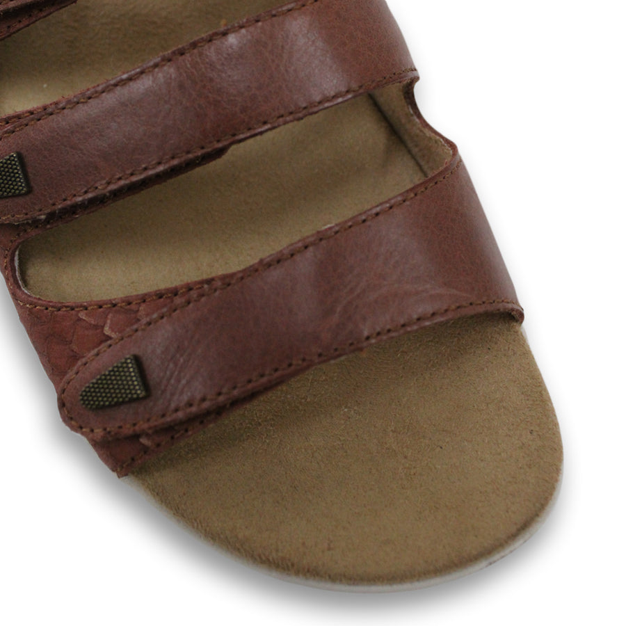 FRONT VIEW OF BROWN FLAT SANDAL WITH TRANGLE TEXTURED SIDE PANELS, OPEN TOE, OPEN BACK, WHITE SOLE AND THREE STRAPS ACROSS THE FRONT 