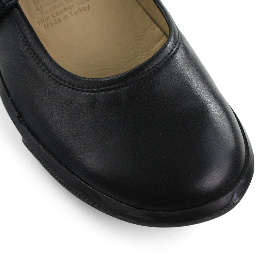 FRONT VIEW OF BLACK CASUAL SHOE WITH MARY JANE STYLE STRAP ACROSS THE TOP
