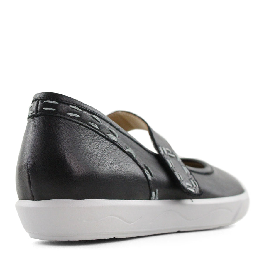 BACK VIEW OF BLACK CASUAL SHOE WITH MARY JANE STYLE STRAP ACROSS THE TOP  AND WHITE STITCH DETAIL   