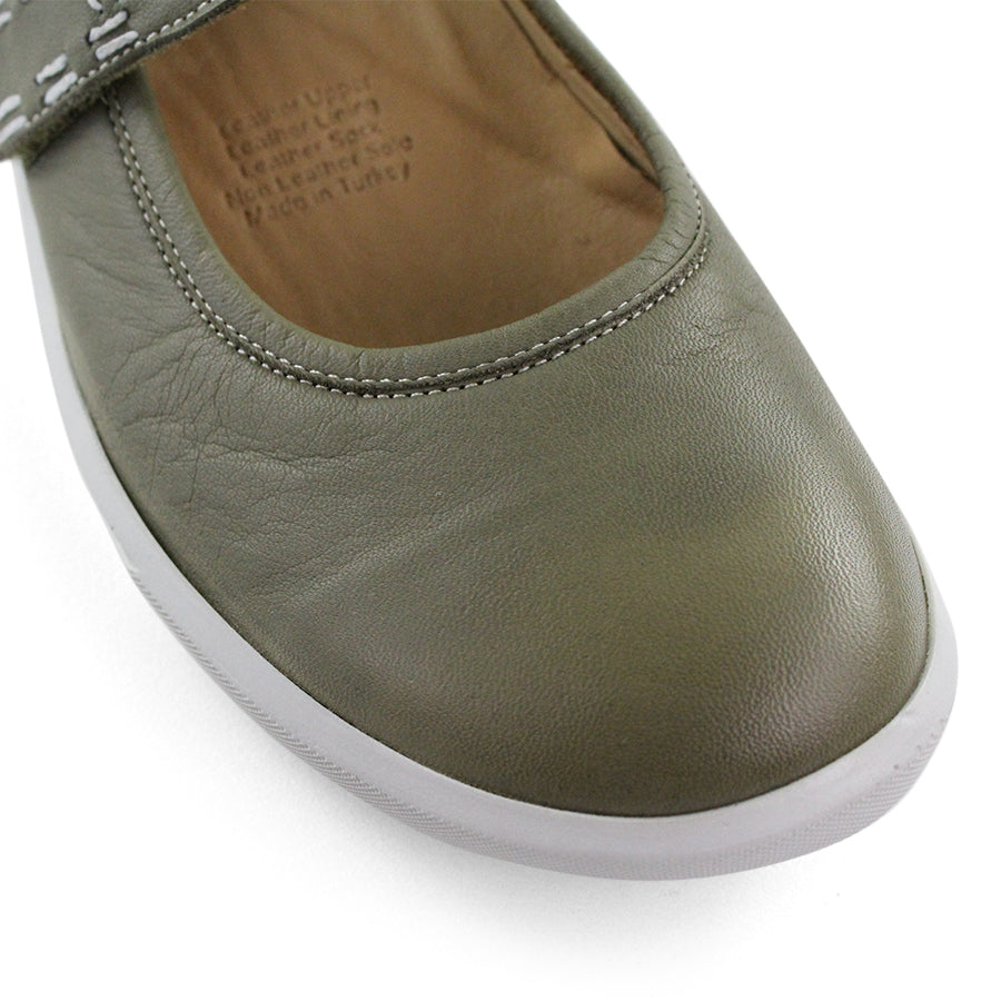 FRONT VIEW OF GREEN CASUAL SHOE WITH MARY JANE STYLE STRAP ACROSS THE TOP AND WHITE STITCH DETAIL  