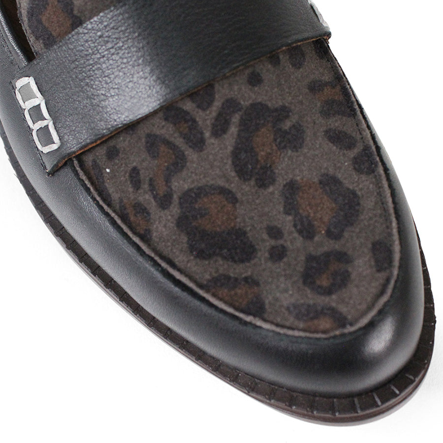 FRONT VIEW OF BLACK FLAT SHOE WITH LEOPARD PRINT FRONT PANEL AND STRAP WITH WHITE STITCH DETAILING 