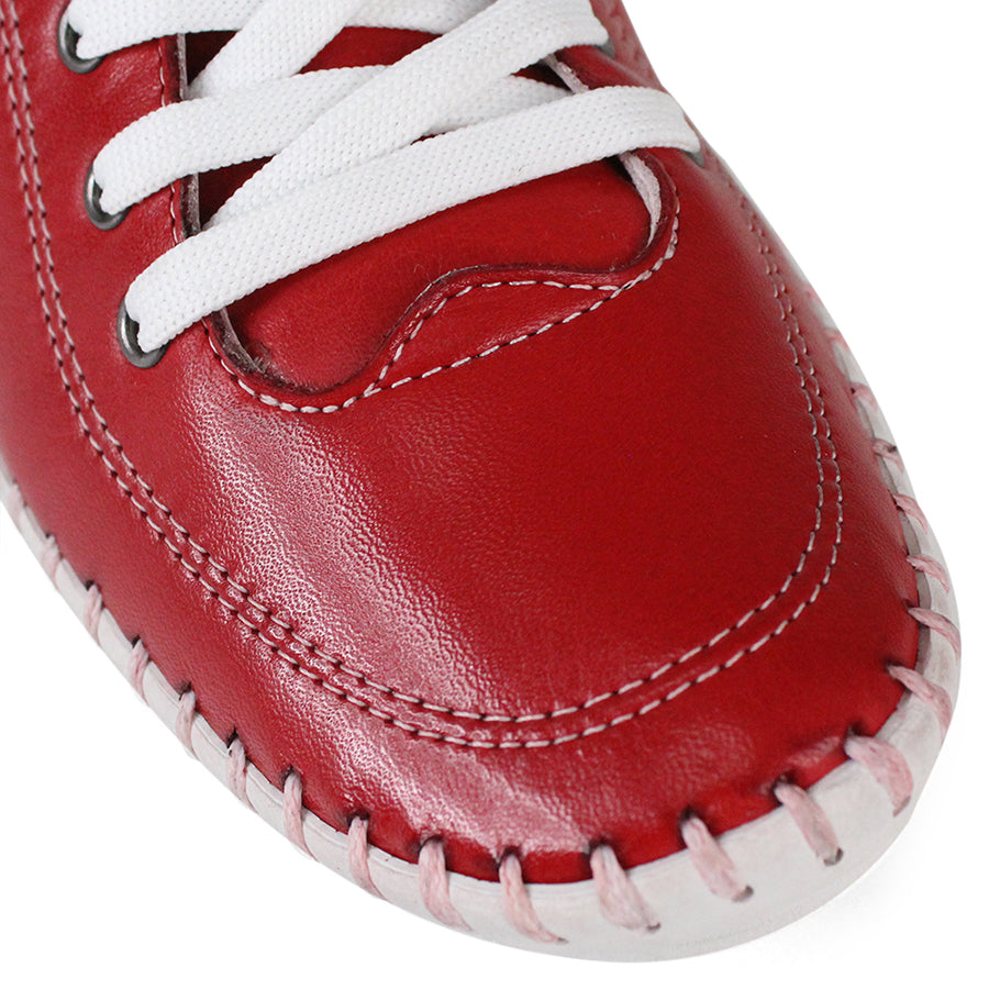 FRONT VIEW OF RED LACE UP CASUAL SHOE WITH WHITE STITCH DETAIL ACROSS THE TOP OF THE SOLE