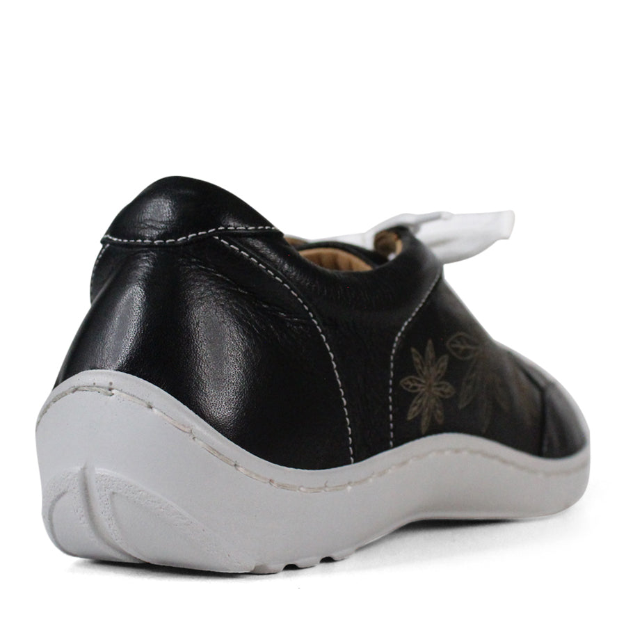 BACK VIEW OF BLACK LACE UP CASUAL SHOE WITH WHITE SOLE AND WHITE STITCHING. FLOWERS ON THE SIDES AND TOP OF THE SHOE 