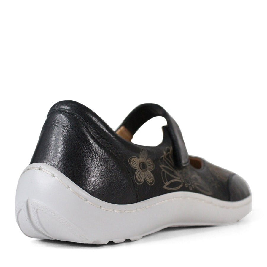 BACK VIEW OF BLACK CASUAL SHOE WITH VELCRO STRAP AND WHITE SOLE. FLOWERS ON THE SIDES AND TOP OF THE SHOE 