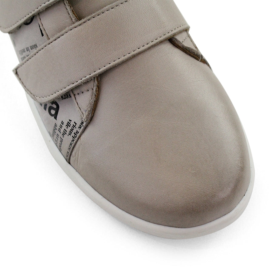 FRONT VIEW OF BEIGE NEWSPAPER PRINT SNEAKER WITH TWO VELCRO STRAPS AND WHITE SOLE  