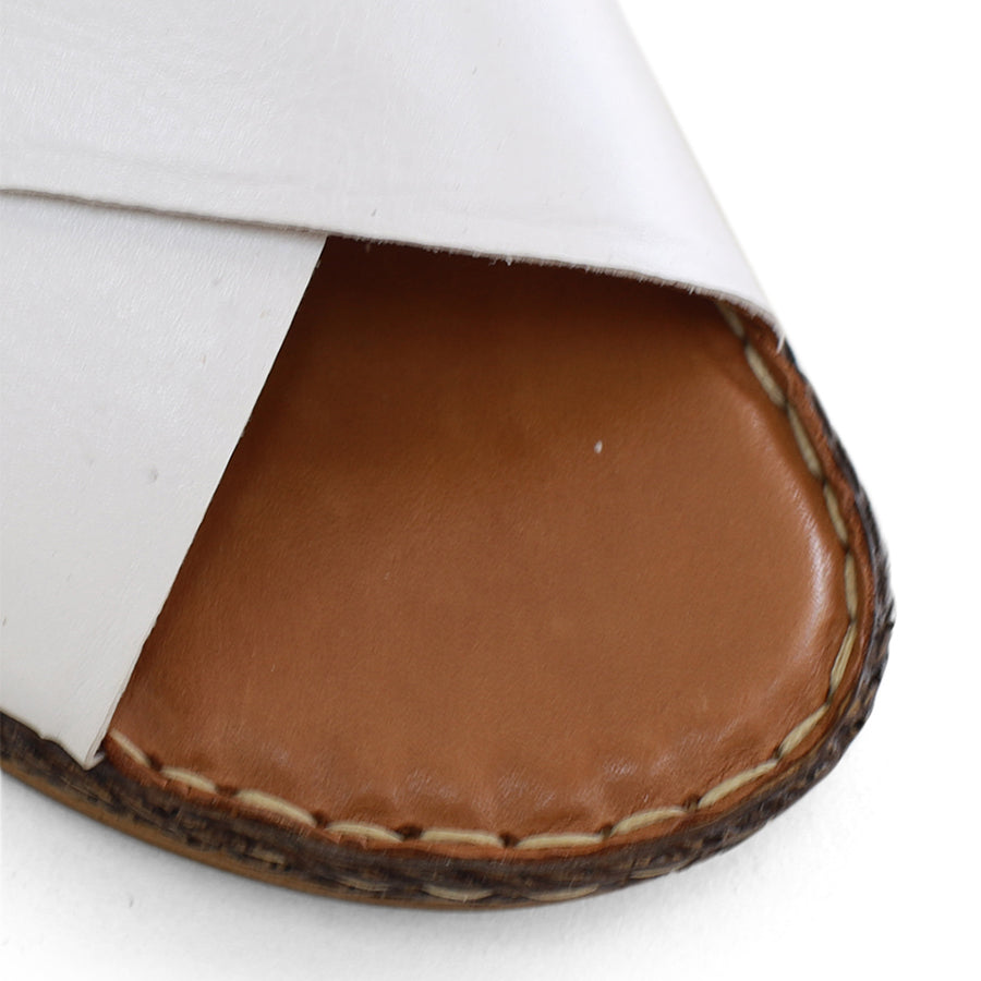 FRONT VIEW OF WHITE LEATHER SANDAL WITH CRISS CROSS DETAIL  