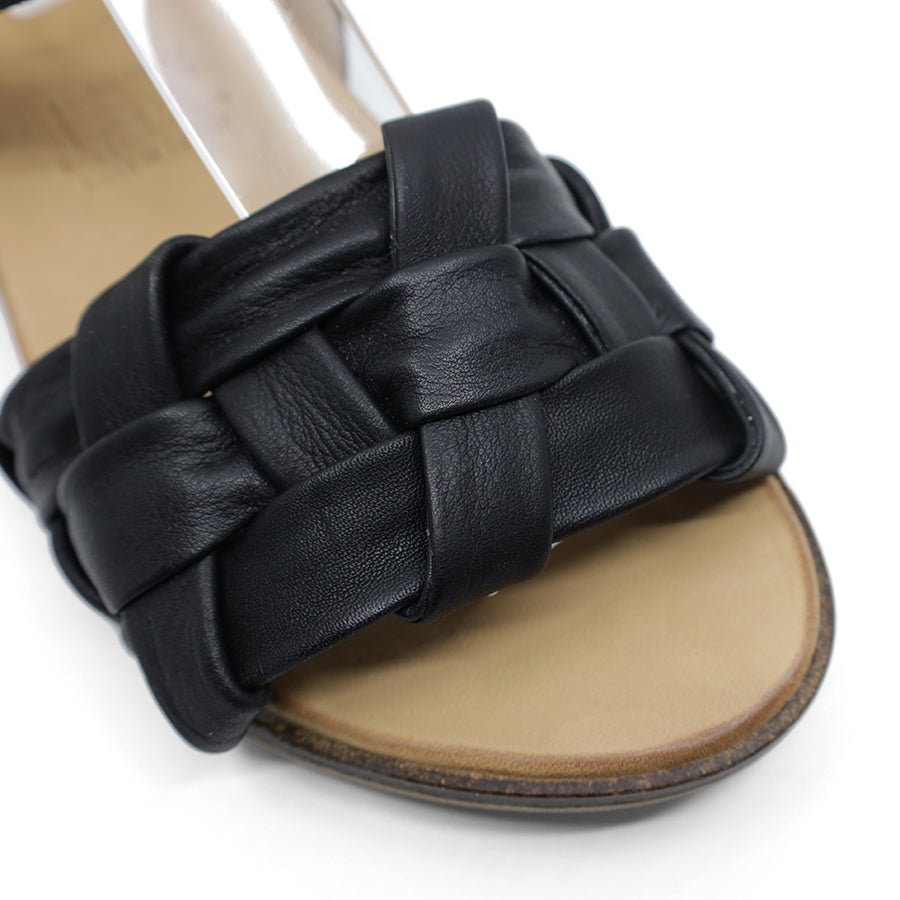 FRONT VIEW OF BLACK LEATHER STRAP SANDAL. FRONT STRAP INTERWOVEN PLAITED LEATHER. 