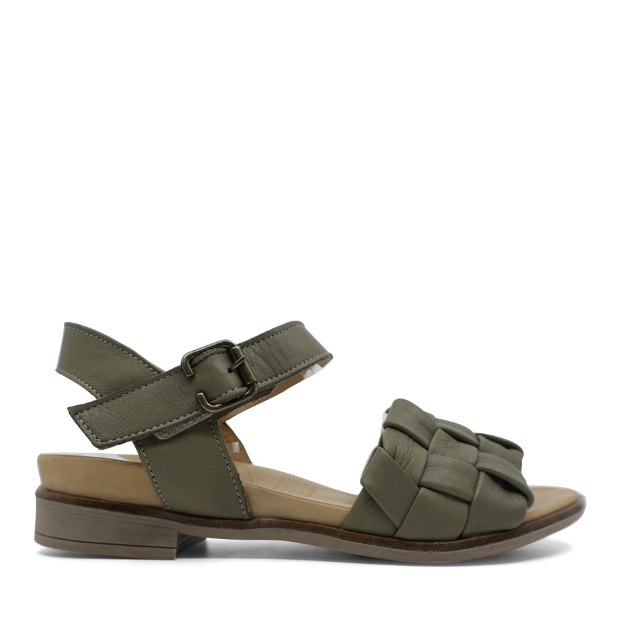 SIDE VIEW OF BLACK LEATHER STRAP SANDAL. FRONT STRAP INTERWOVEN PLAITED LEATHER. VELCRO ADJUSTABLE Y BACK WITH DECORATIVE BUCKLE