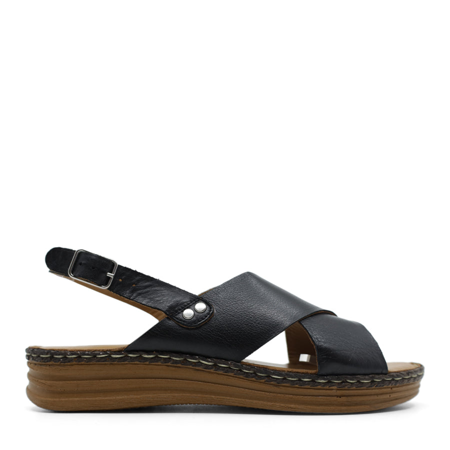 SIDE VIEW OF BLACK LEATHER CRISS CROSS FRONT SANDAL WITH ADJUSTABLE BUCKLE AND CUSHIONED SOLE