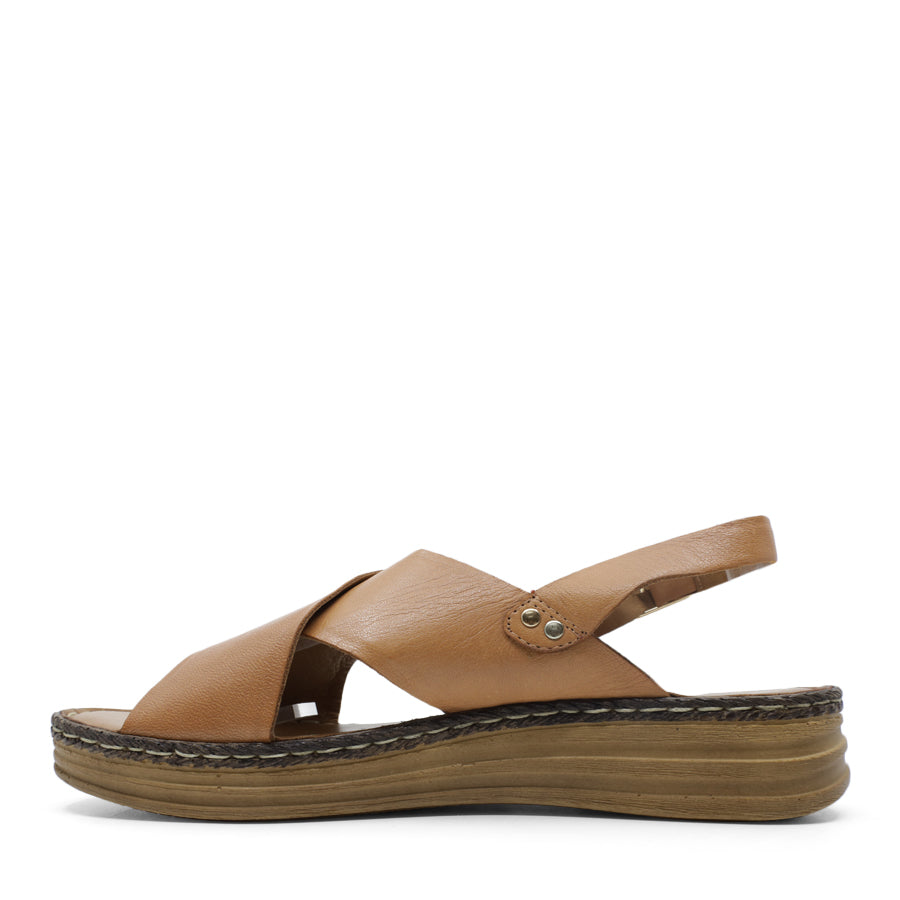 SIDE VIEW OF TAN LEATHER CRISS CROSS FRONT SANDAL WITH ADJUSTABLE BUCKLE AND CUSHIONED SOLE