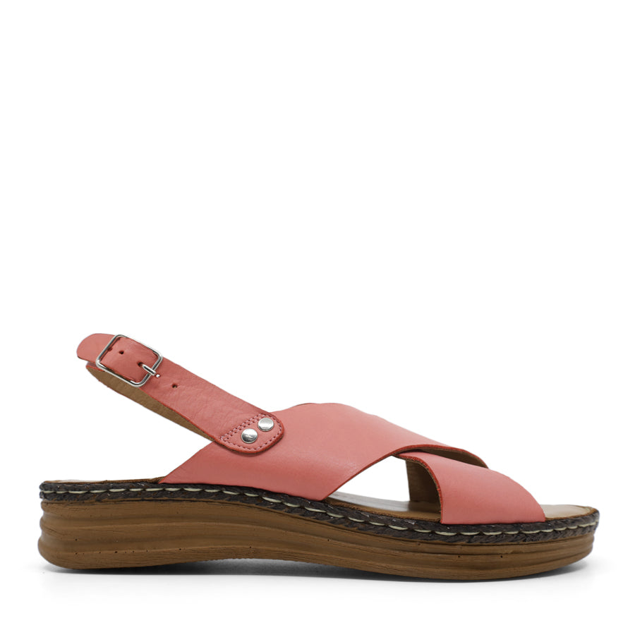 SIDE VIEW OF PINK LEATHER CRISS CROSS FRONT SANDAL WITH ADJUSTABLE BUCKLE AND CUSHIONED SOLE