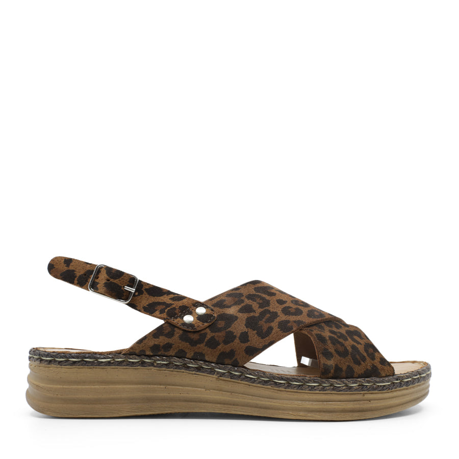 SIDE VIEW OF LEOPARD LEATHER CRISS CROSS FRONT SANDAL WITH ADJUSTABLE BUCKLE AND CUSHIONED SOLE