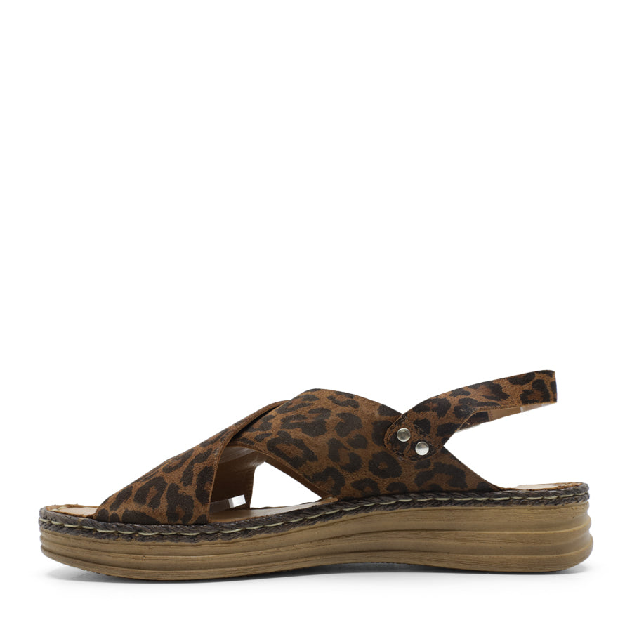 SIDE VIEW OF LEOPARD LEATHER CRISS CROSS FRONT SANDAL WITH ADJUSTABLE BUCKLE AND CUSHIONED SOLE