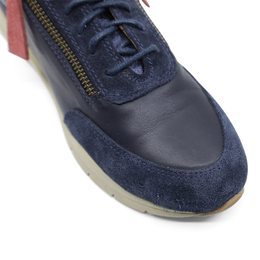 FRONT VIEW OF NAVY CASUAL SHOE WITH RED ZIPPER TAG AND PATCH ON BACK OF HEEL 