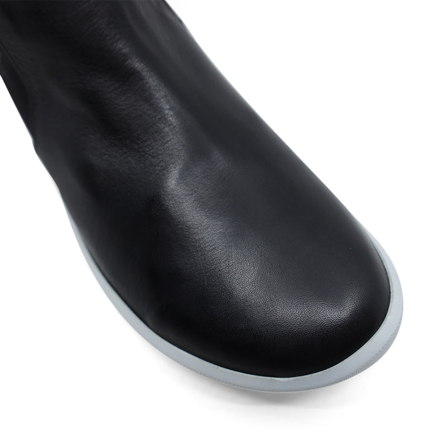 FRONT VIEW OF BLACK LONG BOOT WITH WHITE SOLE
