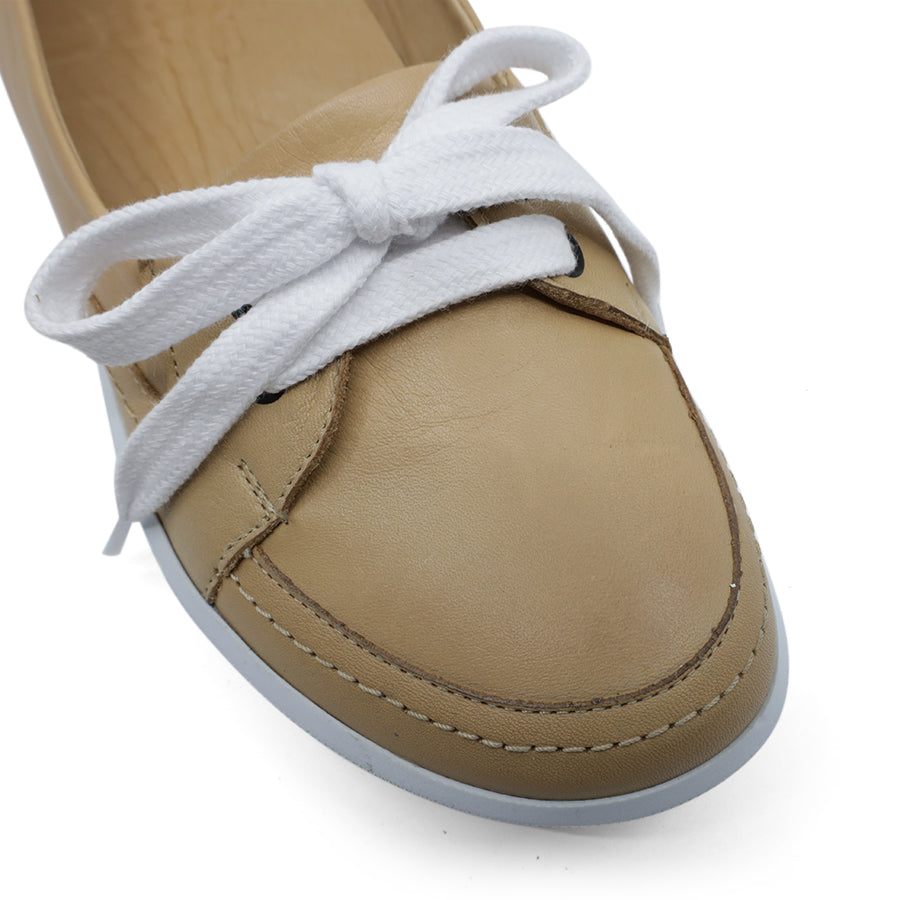 FRONT VIEW OF BEIGE CASUAL SHOE WITH LACES AT THE FRONT AND WHITE SOLE 