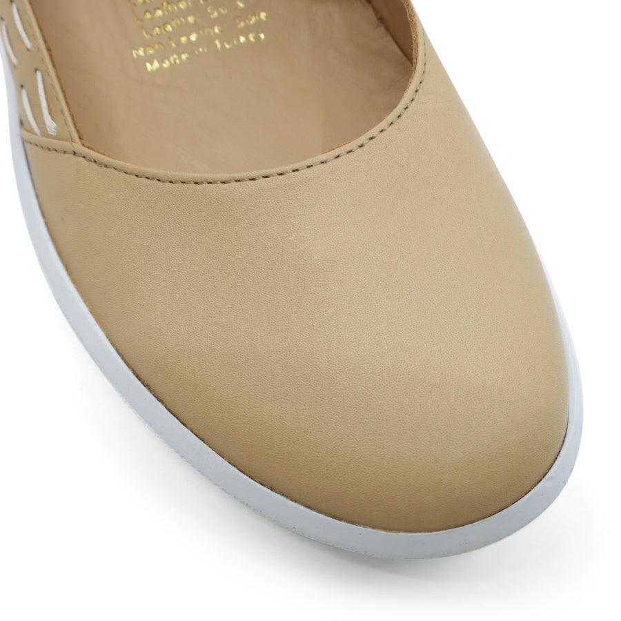 FRONT VIEW OF BEIGE CASUAL SHOE WITH STRAP, WHITE STITCH DETAIL AND WHITE SOLE 