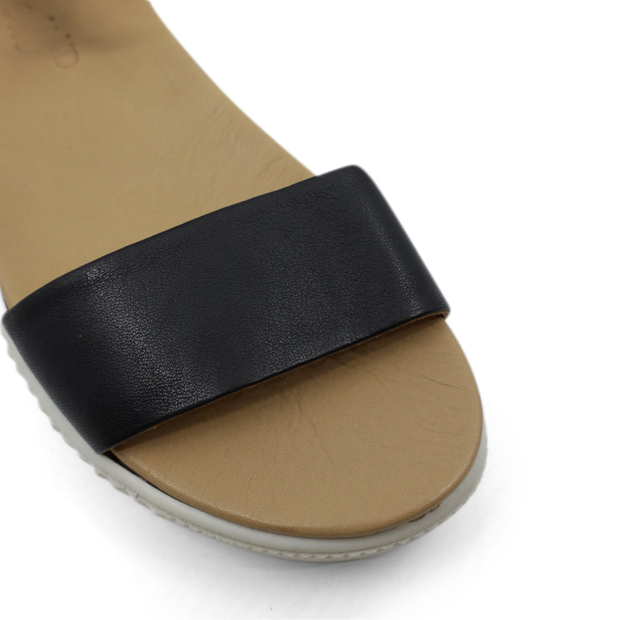FRONT VIEW OF BLACK SANDAL WITH BUCKLE AND WHITE SOLE  