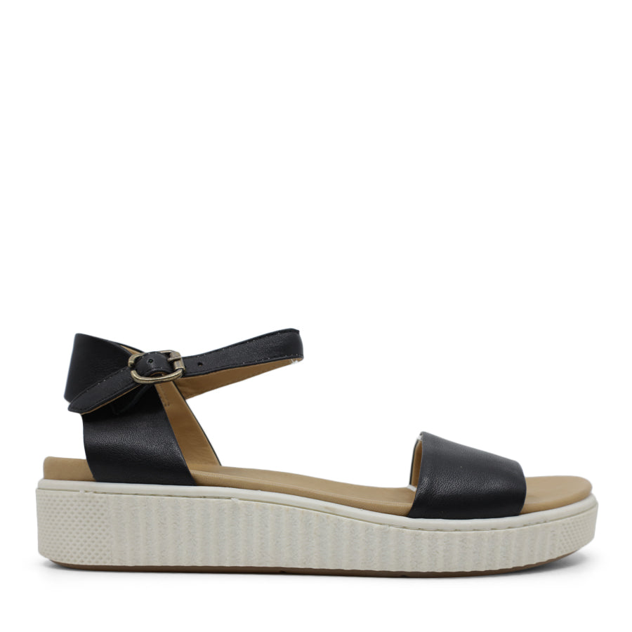 SIDE VIEW OF BLACK SANDAL WITH BUCKLE AND WHITE SOLE  