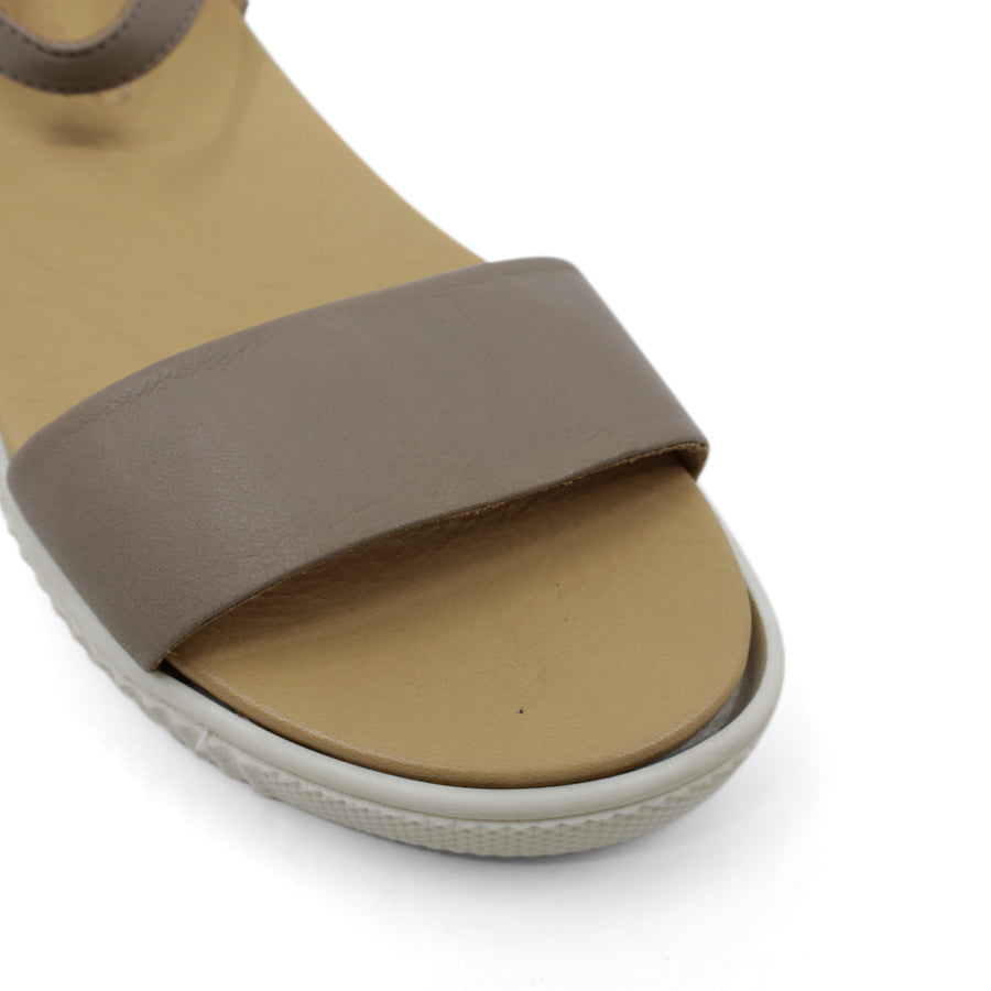 FRONT VIEW OF GREY SANDAL WITH BUCKLE AND WHITE SOLE 