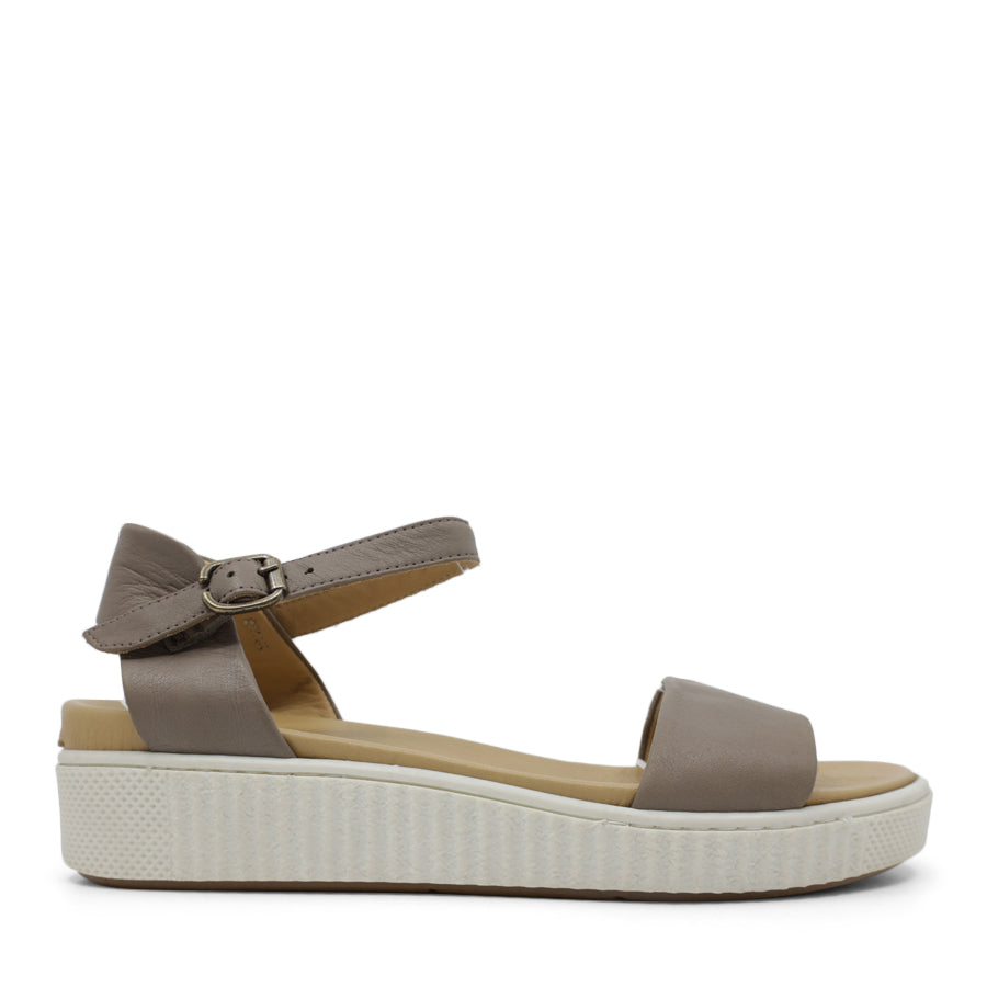 SIDE VIEW OF BLACK SANDAL WITH BUCKLE AND WHITE SOLE  