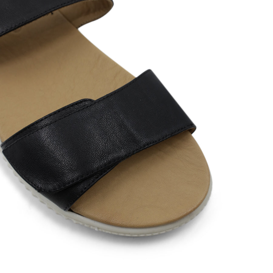 FRONT VIEW OF METALLIC BLACK SANDAL WITH TWO VELCRO STRAPS AND WHITE SOLE