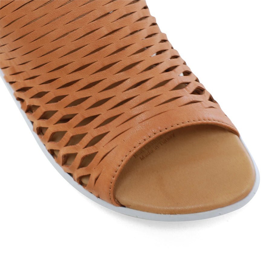 FRONT VIEW OF TAN OPEN TOE SANDAL WITH WHITE SOLE AND VELCRO STRAP AROUND THE HEEL 