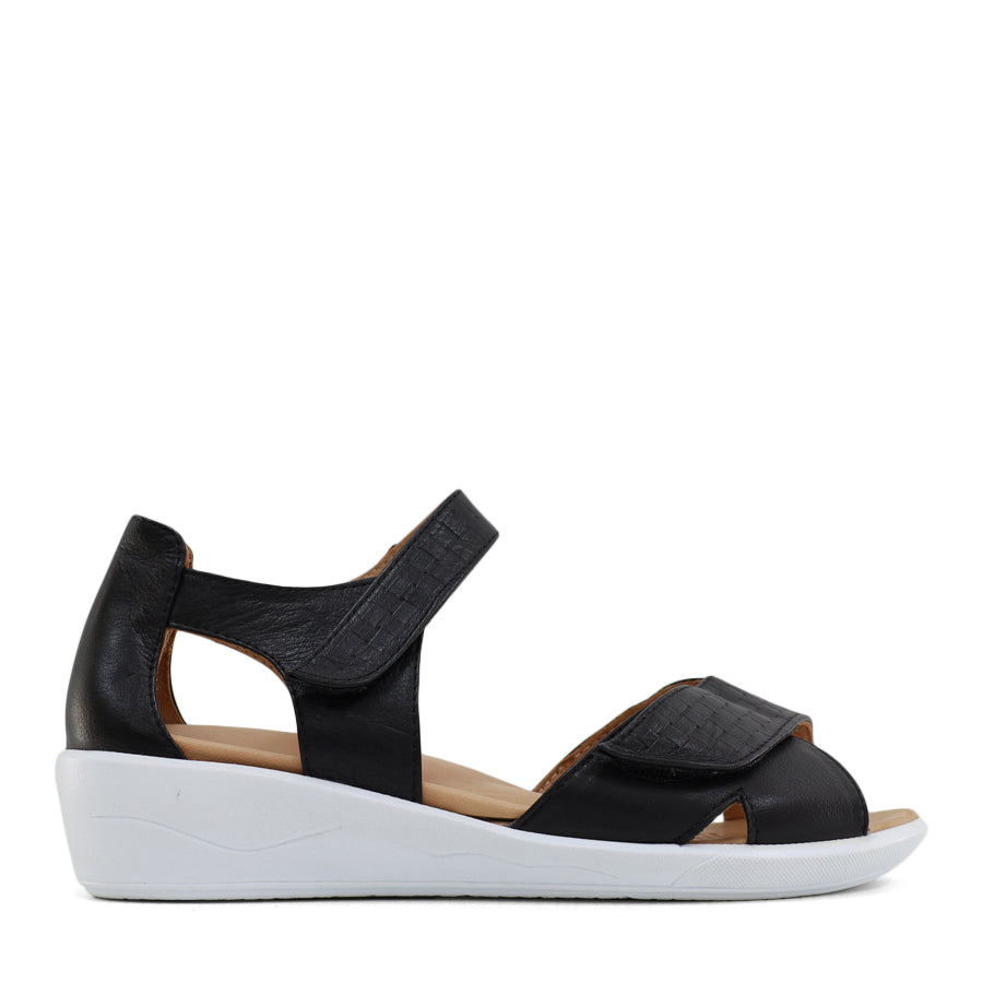 SIDE VIEW OF BLACK OPEN TOE SANDAL WITH TWO VELCRO STRAPS AND WHITE SOLE