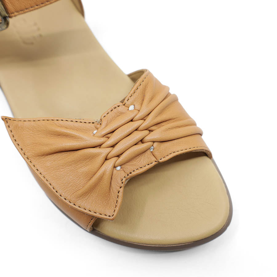 FRONT VIEW OF TAN DUAL VELCRO CLOSED BACK SANDAL WITH DECORATIVE BUCKLE 
